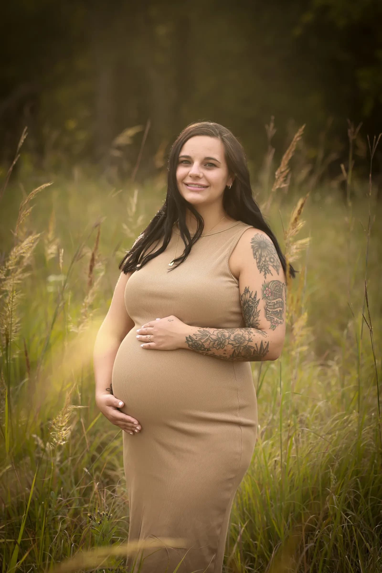 Maternity session in tall grass during golden hour