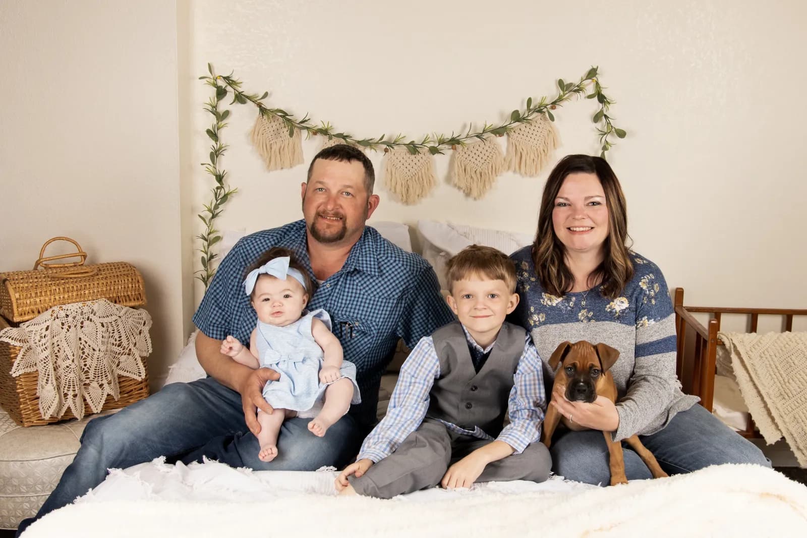 Family with 2 childrenposed on bed
