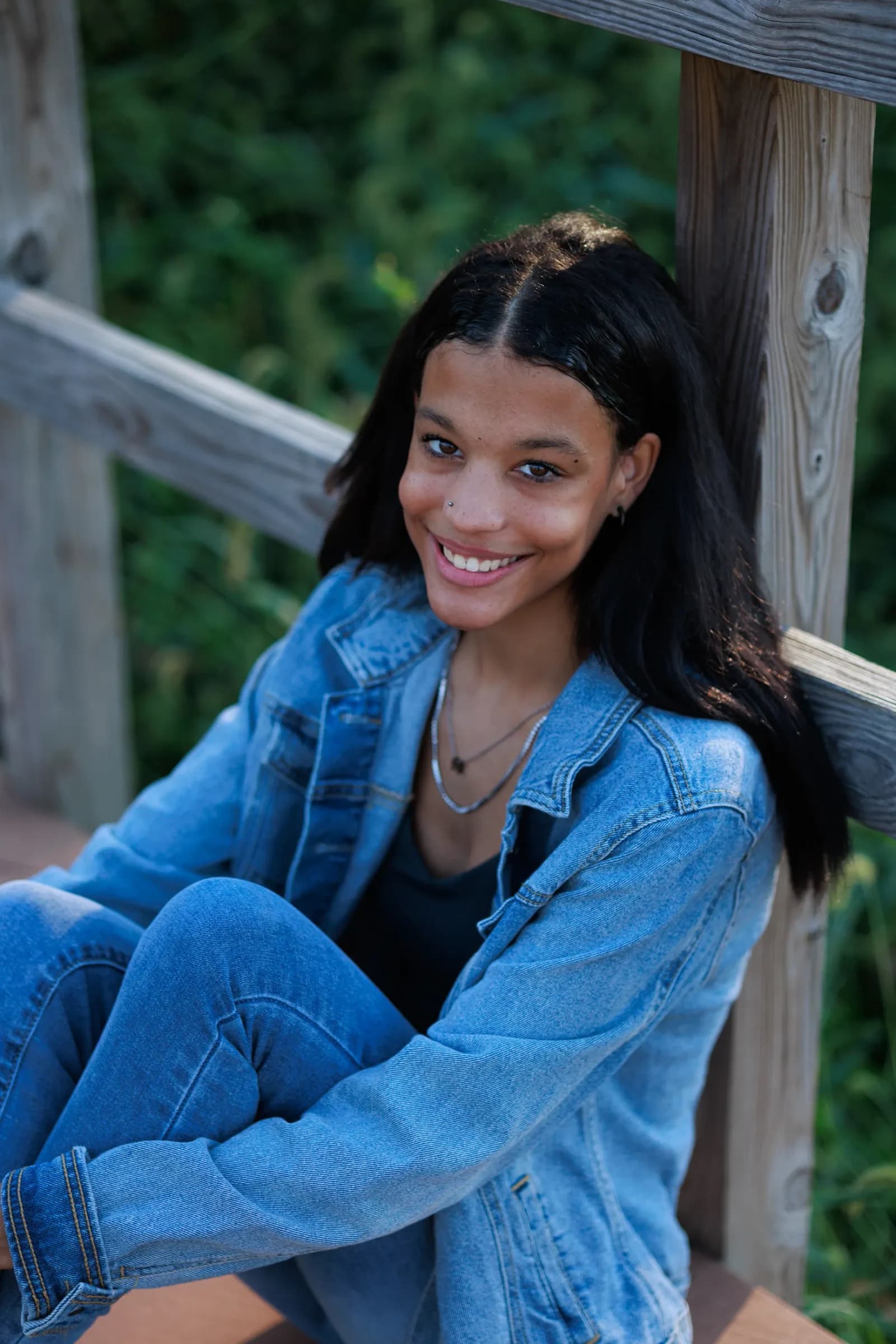 Girl sitting against rails of bridge