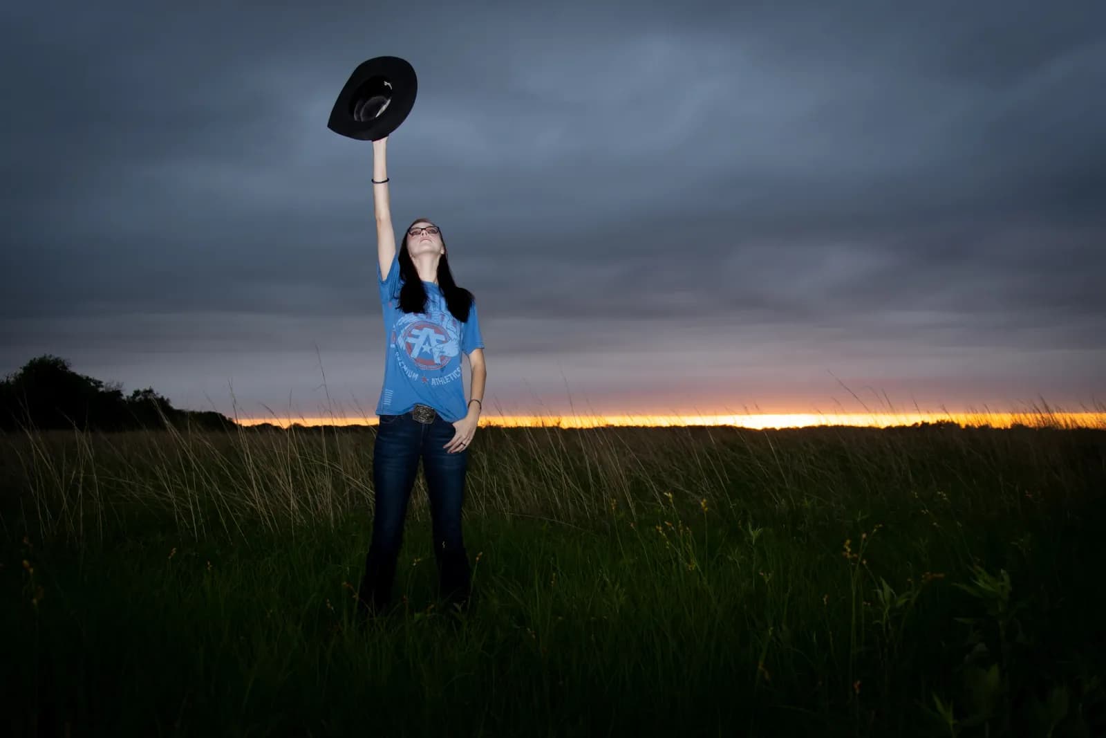 Senior girl with cowboy hat at sunset